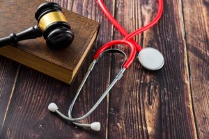 Doctor stethoscope, gavel, and law book for malpractice